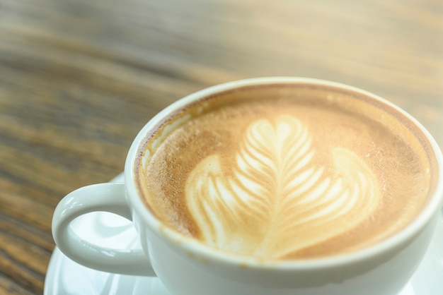 Coffee latte art on wooden table.