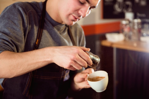 Coffee Latte Barista making pattern in a cup of coffee shop.