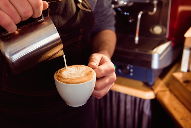 一杯のコーヒーショップでパターンを作るコーヒーラテバリスタ。