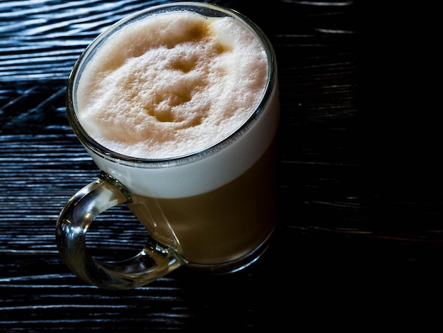 Coffee latte on black wood table near window Coffee break