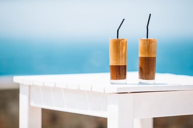 Coffee latte on wooden table with sea background