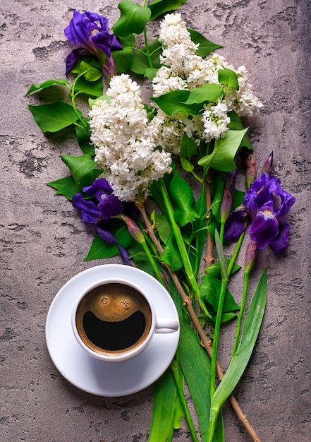 Coffee and lilac flowers on grey concrete table