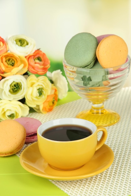 Coffee and macaroons on table on light background