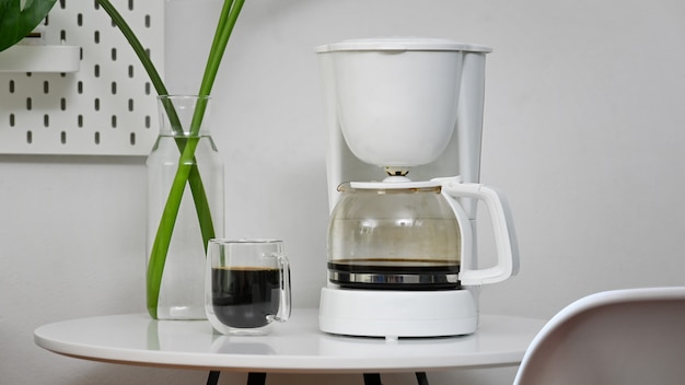 Coffee machine and coffee cup in office room.