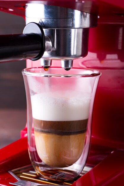 Coffee machine preparing cappuccino in double glass