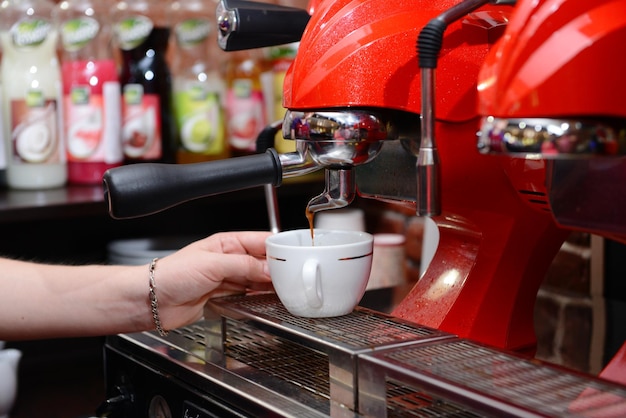 一杯のコーヒーを準備するコーヒー マシンをクローズ アップ