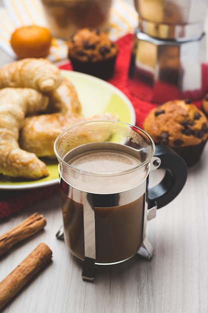 Foto macchina da caffè, muffin, croissant e tazza di caffè