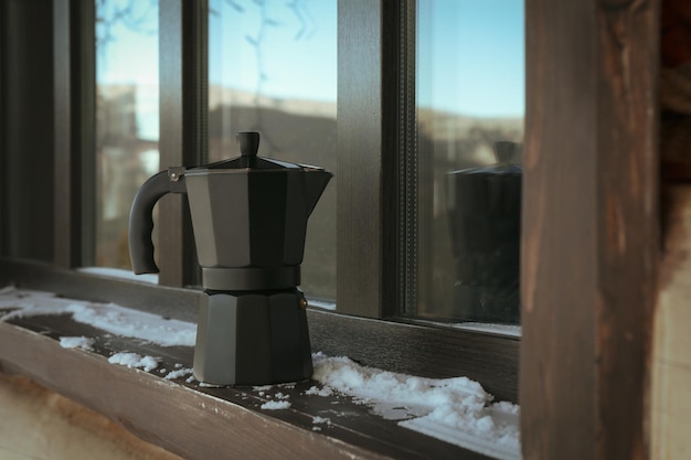 Coffee maker outdoor on windowsill in winter day