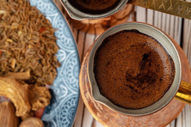 Caffè in metallo turco con spezie in un piatto