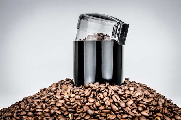 Coffee mill and pile of coffee beans isolated on white