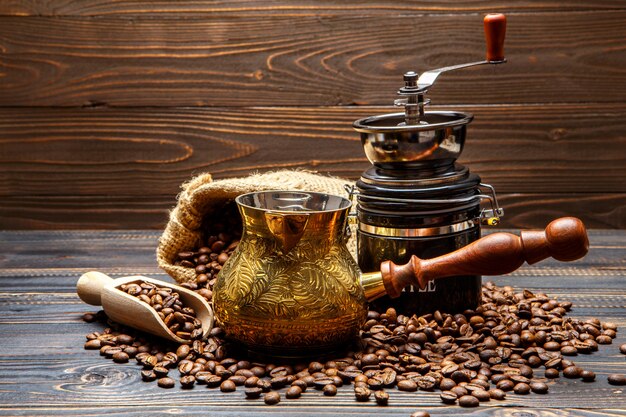 Coffee mill and roasted beans on wooden background