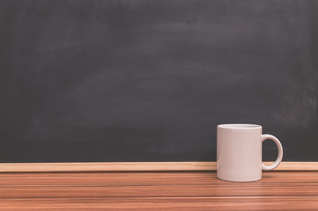 Coffee mug on the desk Blackboard background The concept of love to drink