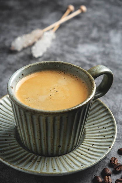 Coffee in a mug on a saucer on a gray background.