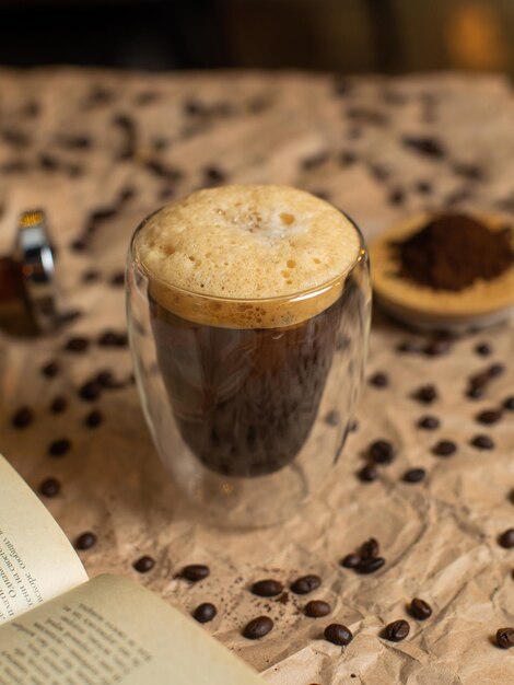 A coffee mug with coffee beans on the top and a book of coffee beans on the right.