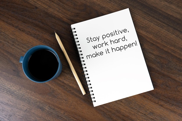 Coffee and note pad with text Stay positive work hard make it happen