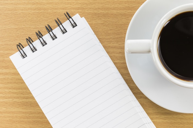 Coffee and notepad on wood table