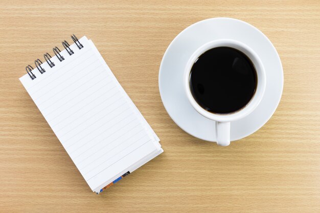 Coffee and notepad on wood table