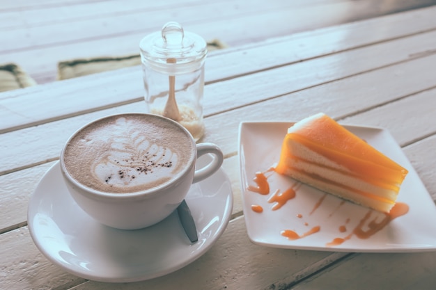 Coffee and orange cake on wooden table. Vinge tone