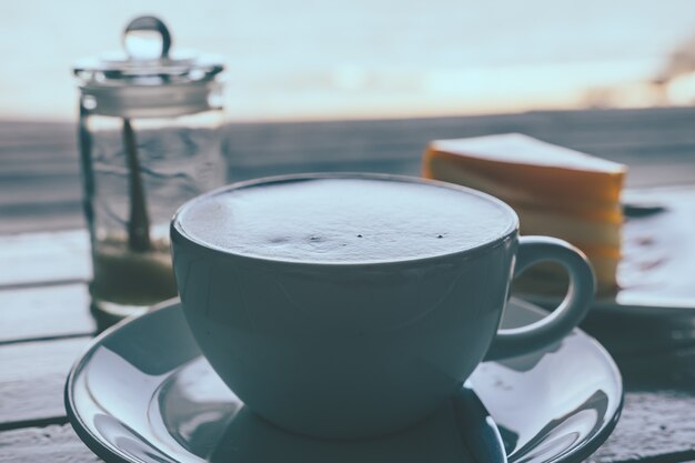 Coffee and orange cake on wooden table. Vinge tone