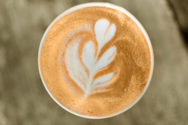 Coffee in a paper cup on a wooden table