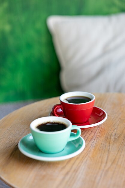 Coffee in red and mint cups on a wooden table americano espresso cappuccino