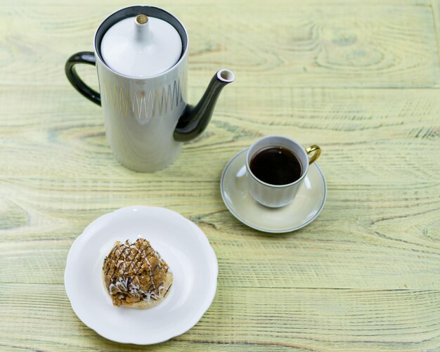 Coffee in a retro cup and cake on a wooden background