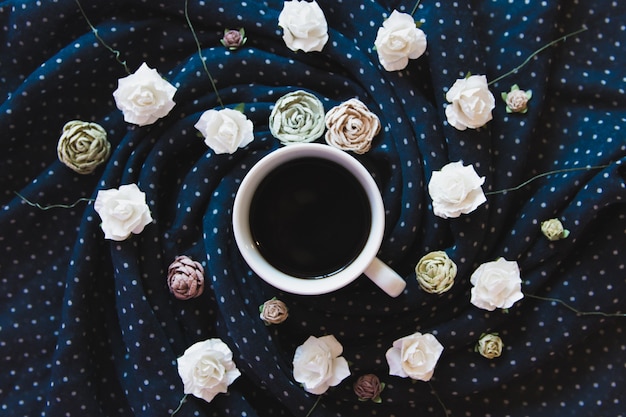 coffee among the roses wrapped in a scarf