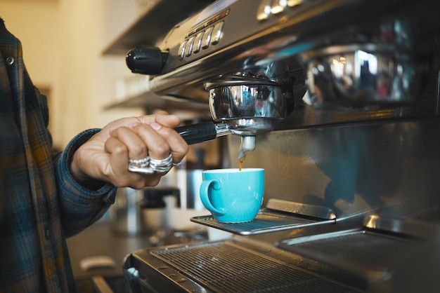 Coffee shop machine handle hand of barista brewing espresso in restaurant and closeup of hot water beverage in cafe Caffeine drink in mug person holding tool on morning in kitchen and breakfast