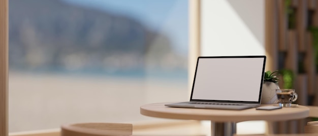 Coffee shop seating space with a laptop computer mockup on coffee table near the window 3d render