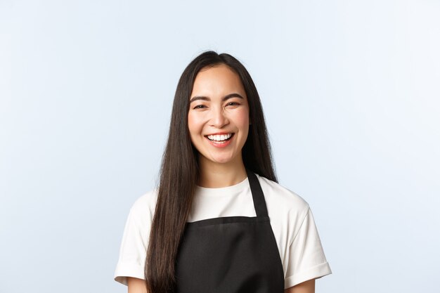 Coffee shop, small business and startup concept. Carefree smiling, cheerful asian female smiling and laughing, upbeat atmosphere at cafe, serving coffee to clients, white background