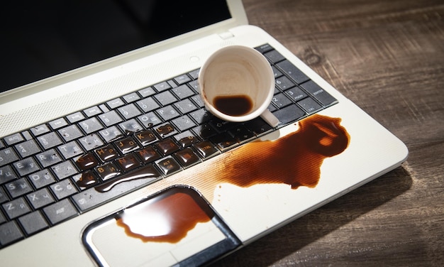 Photo coffee spilled over laptop keyboard