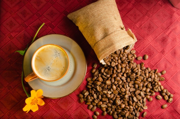 coffee still life on a table with roasted coffee beans on a red tablecloth