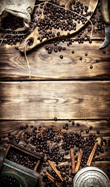 Coffee style. Old coffee grinder with coffee beans on wooden table.