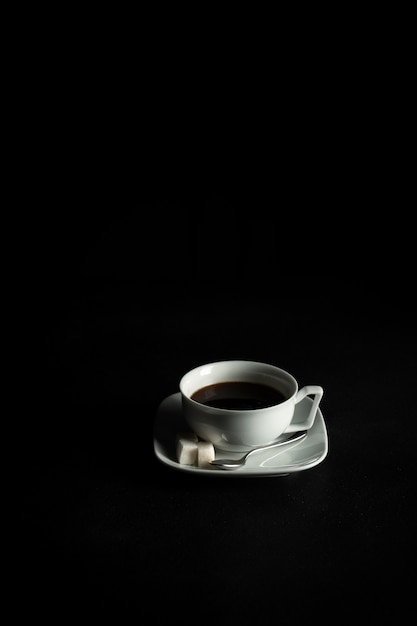 Coffee and sugar in white cupe with saucer