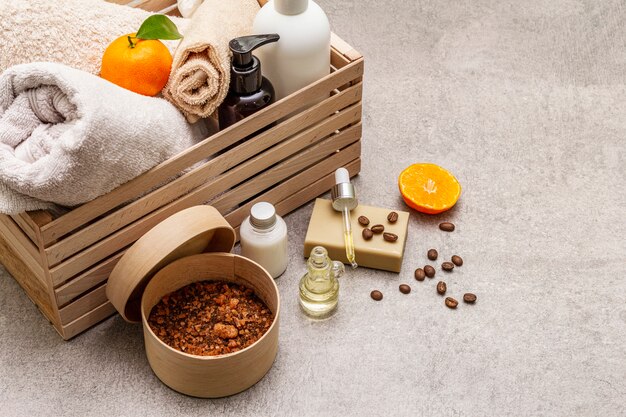 Photo coffee and tangerine spa concept. towels, oil, scrub, soap, lotion. natural ingredient, wooden box.