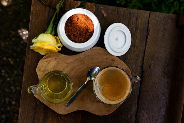 Coffee and tea are on the wooden table in green garden