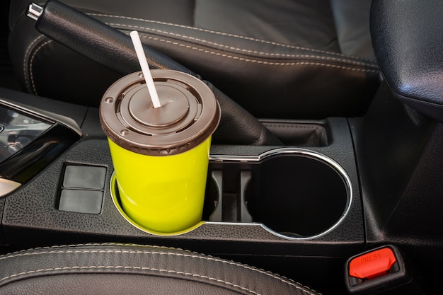 Coffee or tea mugs green placed on the vehicle console in modern luxury car interior