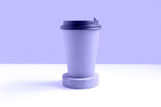 Photo coffee or tea paper cup mockup with lid on violet background zero waste disposable recycled cup