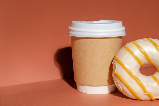 Coffee to go container en donut op minimale achtergrond Fast food concept