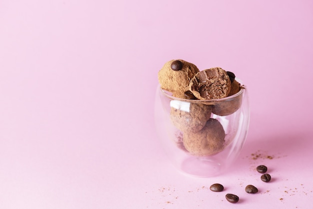 Coffee truffles in a glass on a pink background sugar gluten and lactose free vegan