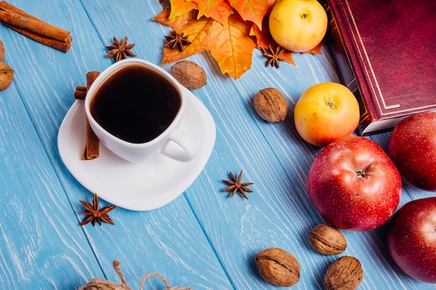 Caffè in una tazza bianca e piattino su un tavolo blu