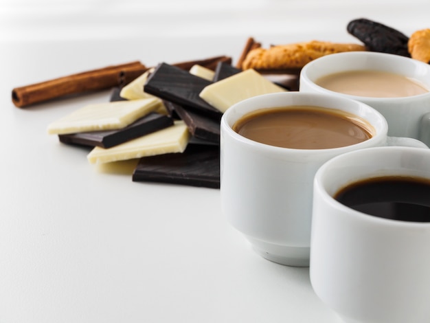 Coffee in white cups with cookies and chocolate