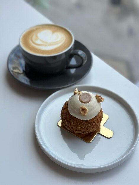 Foto caffè con cuore e dessert pasticceria francese choux