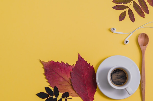 Foto caffè con erbario e cuffie su sfondo giallo. autunno.