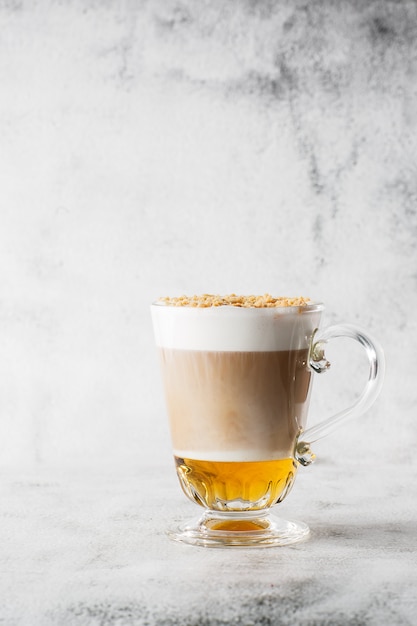 Coffee with Irish whiskey and whipped cream in glass isolated on bright marble background. Overhead view, copy space. Advertising for cafe menu. Coffee shop menu. Vertical photo.