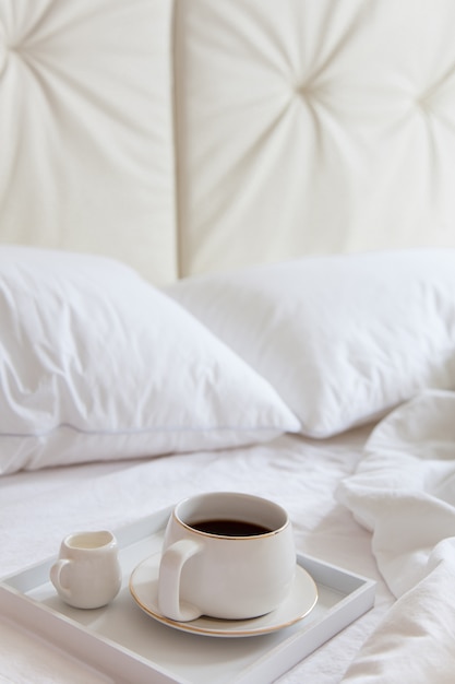 Coffee with milk on a tray in bed