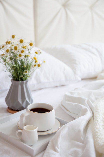 Coffee with milk on a tray in bed