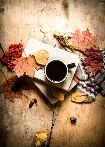 Foto caffè con libri antichi e foglie colorate