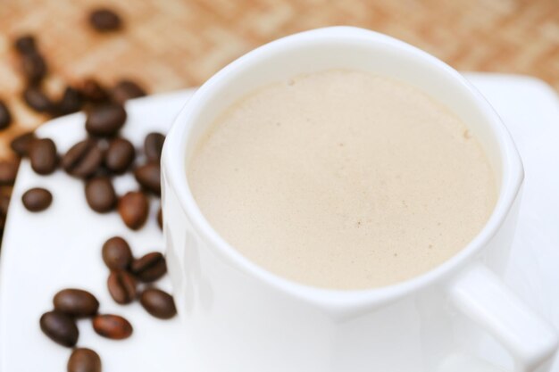 Coffee with roasted beans on textured surface