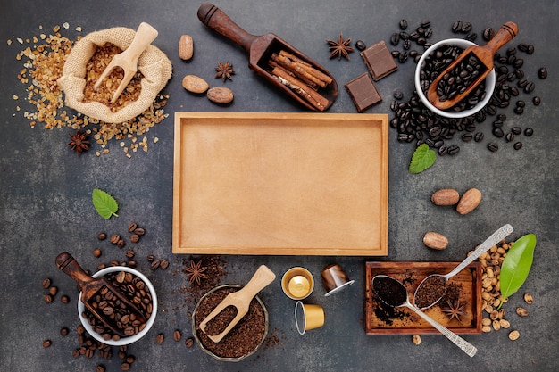 Coffee with various of roasted coffee beans and flavourful ingredients for make tasty coffee setup on dark stone.